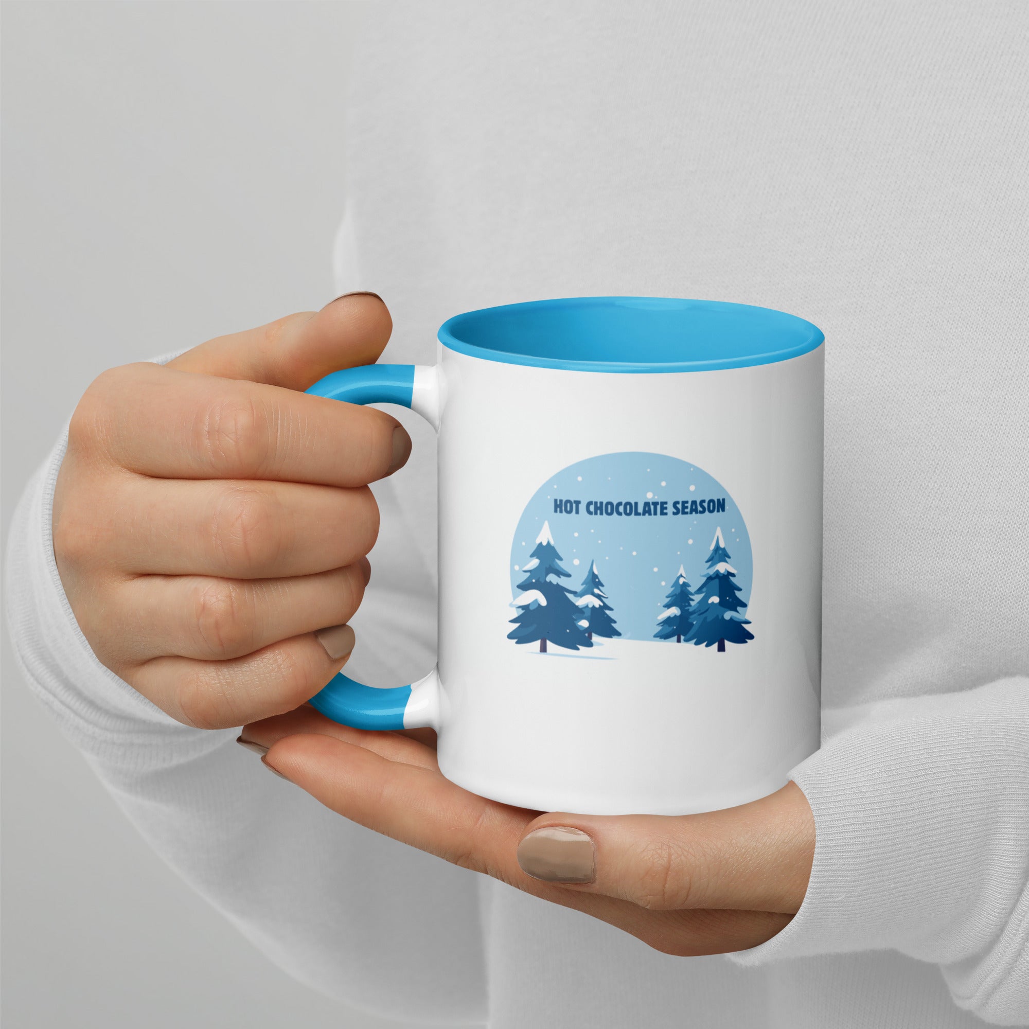 Hot chocolate season white mug with blue interior in hand